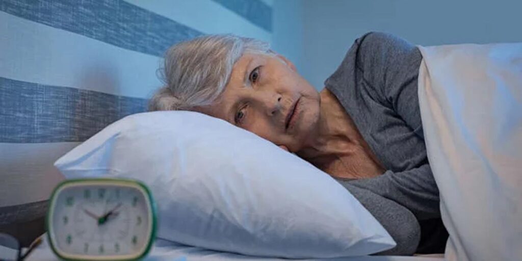 Don't Worry if You Aren't Ready for Retirement elderly lady in bed looking at the alarm clock.