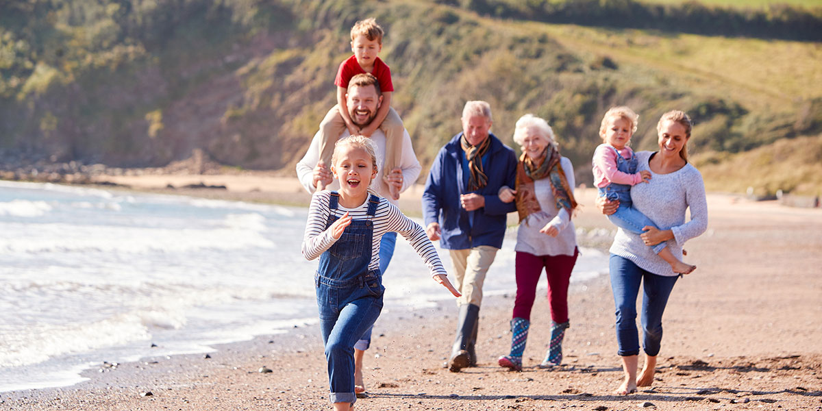 legacy planning - family on the beach with grandparents, grandkids and daughter with husband